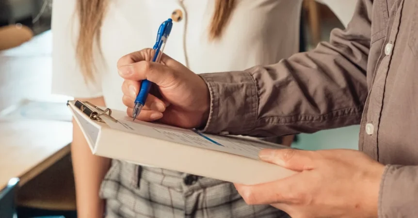 Man holding pen signing Florida estate planning document with woman nearby.
