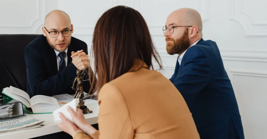 Two lawyers discussing estate planning tools with a client at a desk in a professional office setting.