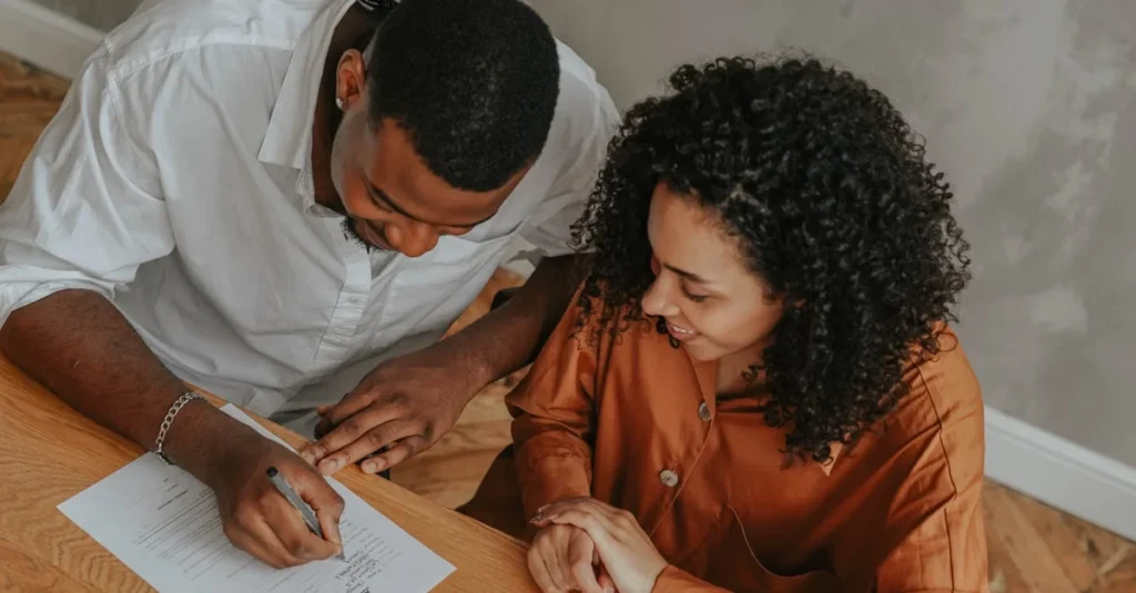 Couple reviewing probate requirements document together at wooden table for estate planning.